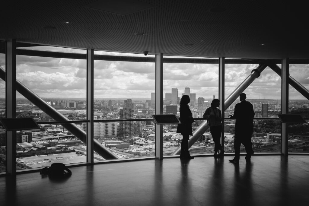 People looking out of a window at a city skyline, reflecting on business development opportunities.