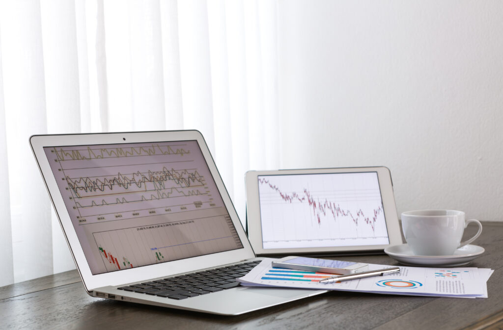 A laptop displaying a stock chart with upward and downward trends on its screen