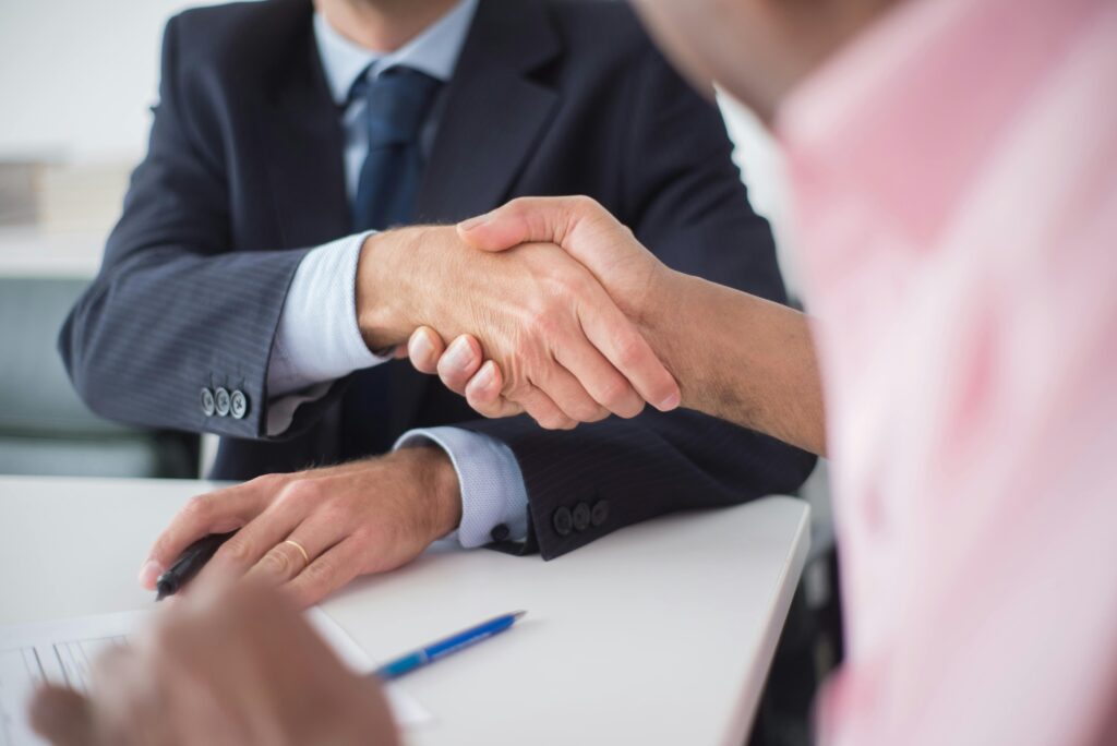 Two individuals shaking hands, symbolizing a professional partnership and collaboration.