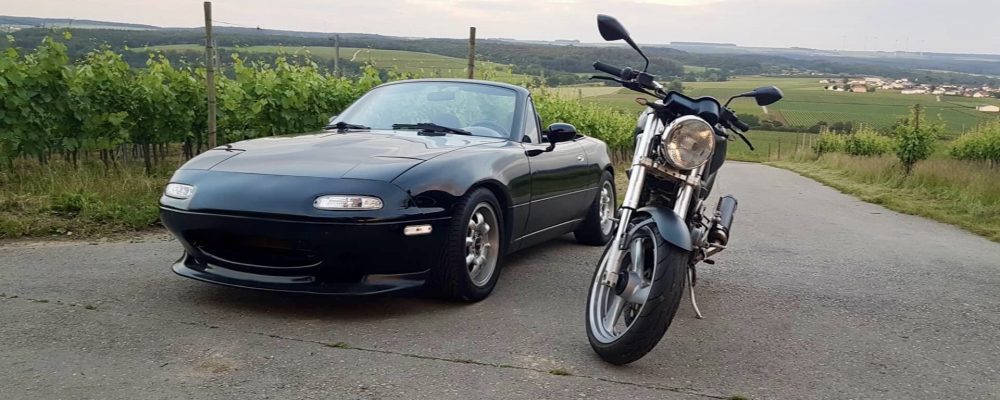 A 1994 Miata and a Ducati motorcycle in a field, representing my passion for cars and motorcycles.